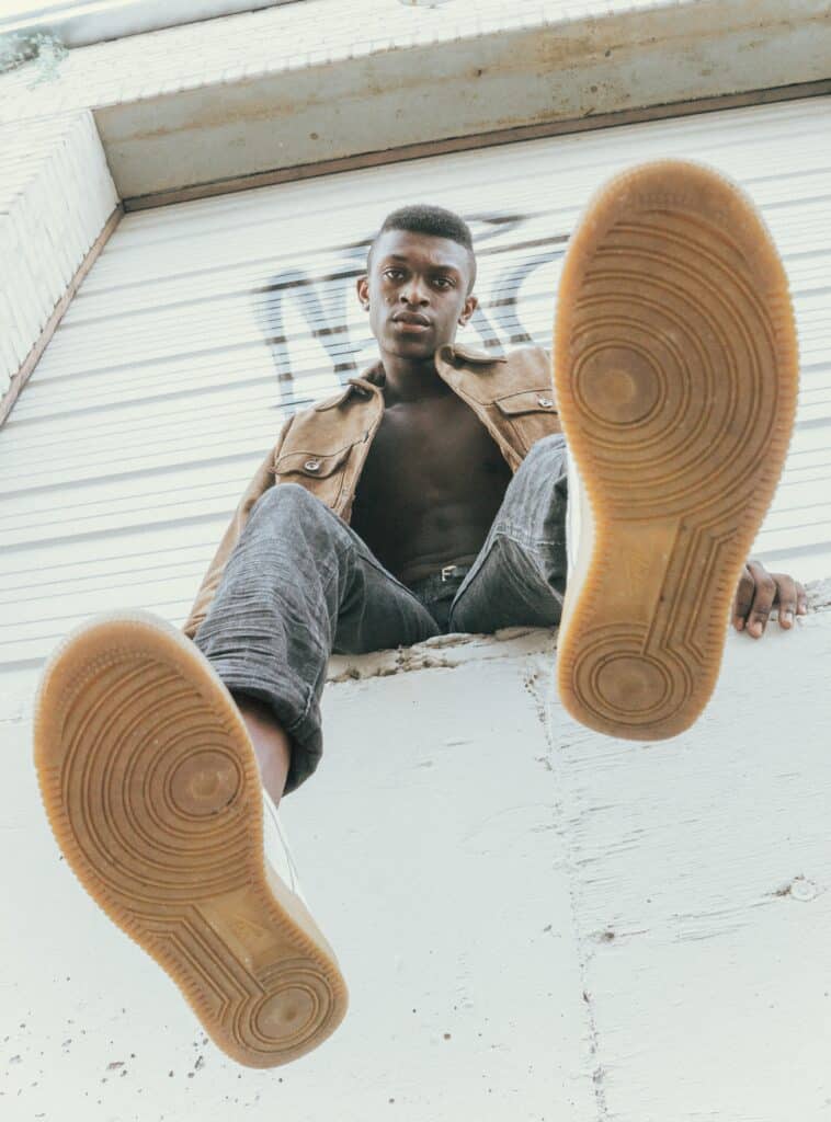 man sitting on wall, taken from below his feet