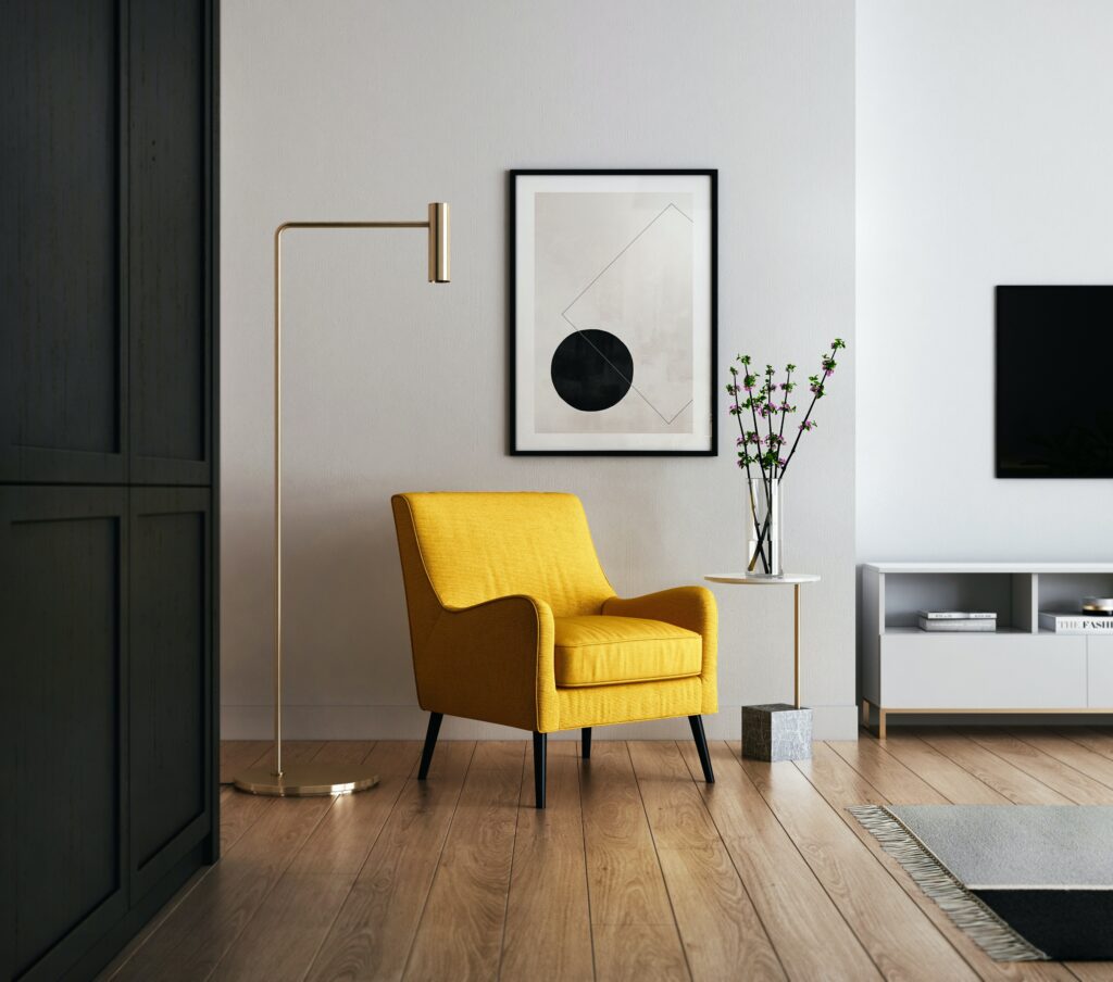 modern minimalist living room with yellow chair, black cabinets, black and white framed painting on white walls, and brass floor light