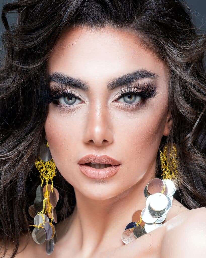 woman with dark, manicured eyebrows and large earrings