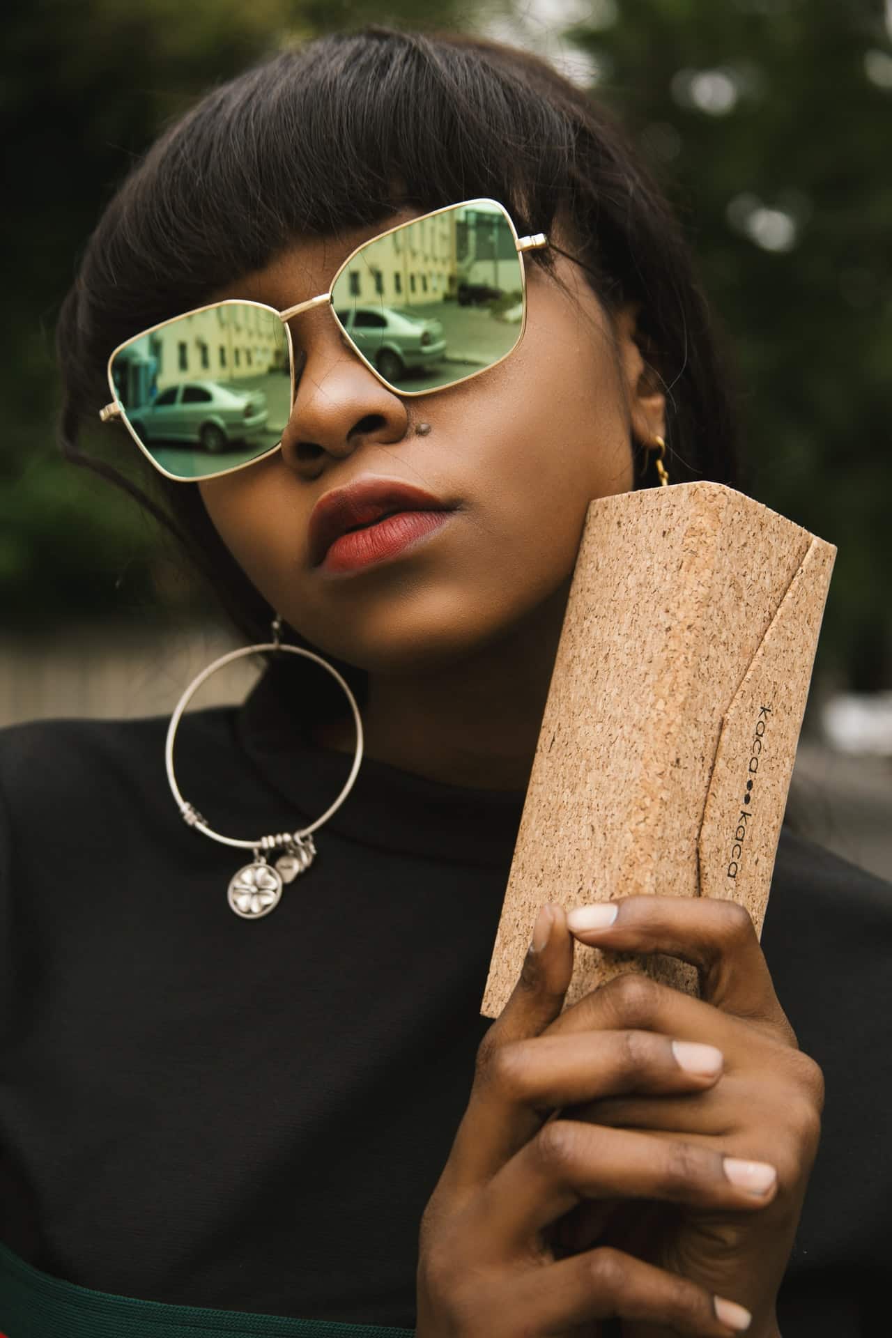 woman wearing sunglasses and holding glasses case